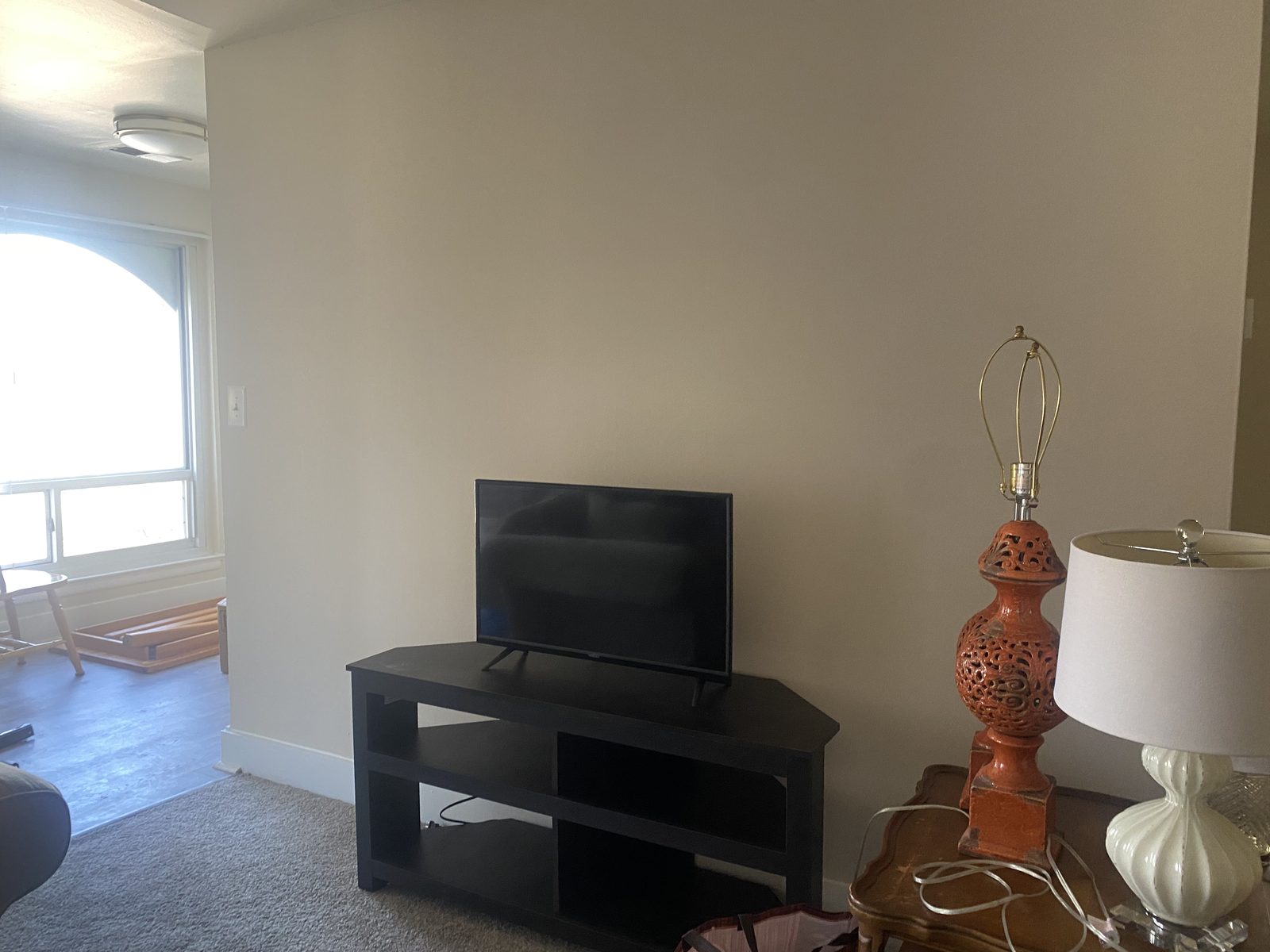 A newly furnished living room with TV stand and lamps, ready for a family to move in