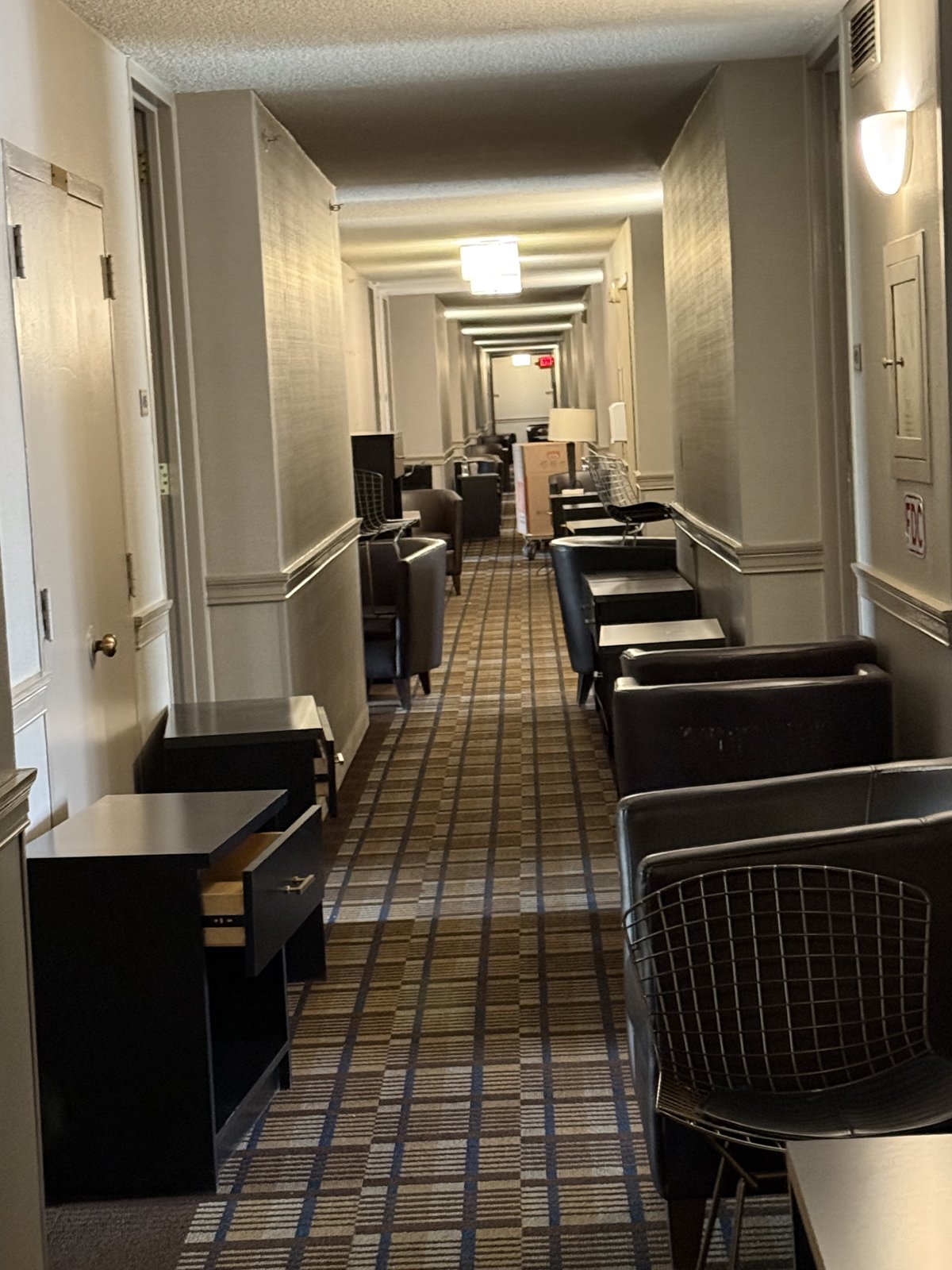 A hotel corridor lined with furniture ready for pickup